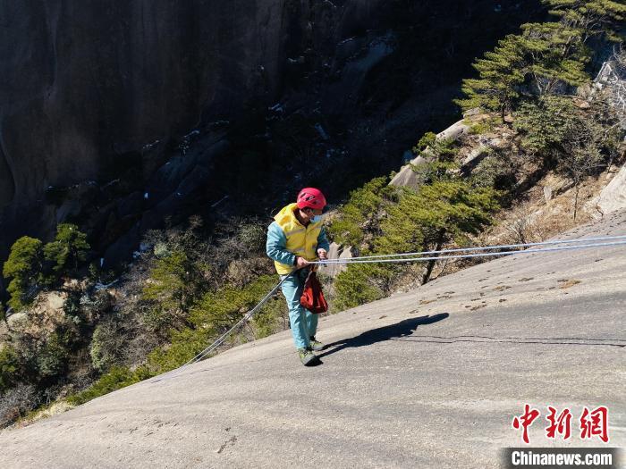 放绳工在悬崖峭壁上捡拾垃圾。杨缪 摄