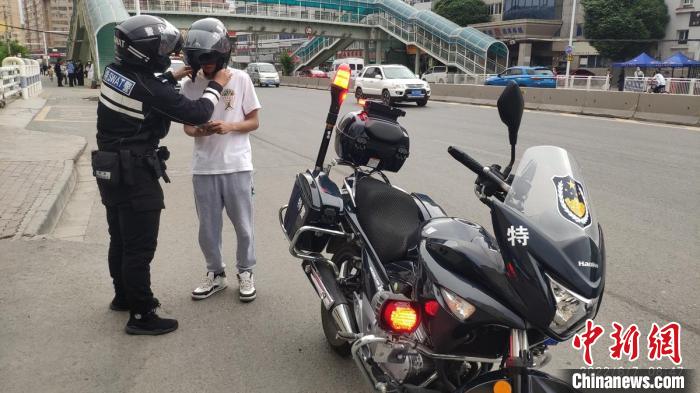 7日晨，乌鲁木齐一名参加高考的学生，因为走错考场，民警屈颖超立即发动摩托车送学生去另外一考点。　李小艺 摄